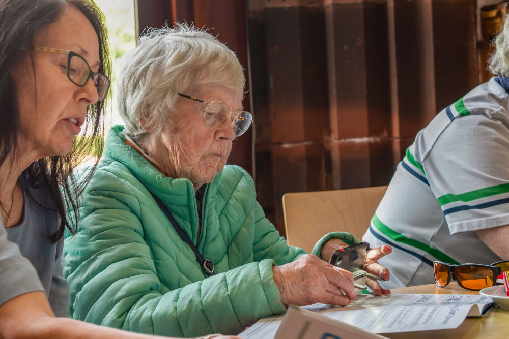 Social group member using a digital magnifier to read text